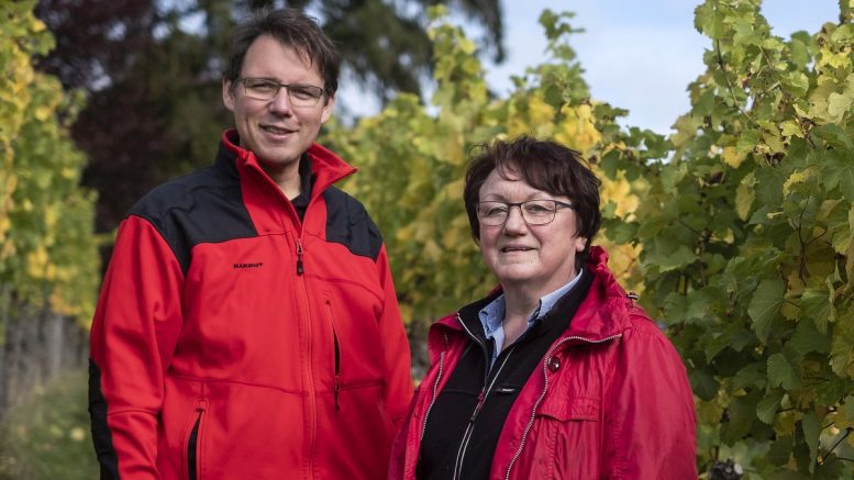 Zwei Weingutbesitzer in einem Weinberg bei Heilbronn in roten Jacken