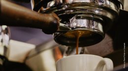 Ein Espresso läuft durchs Sieb in die Tasse