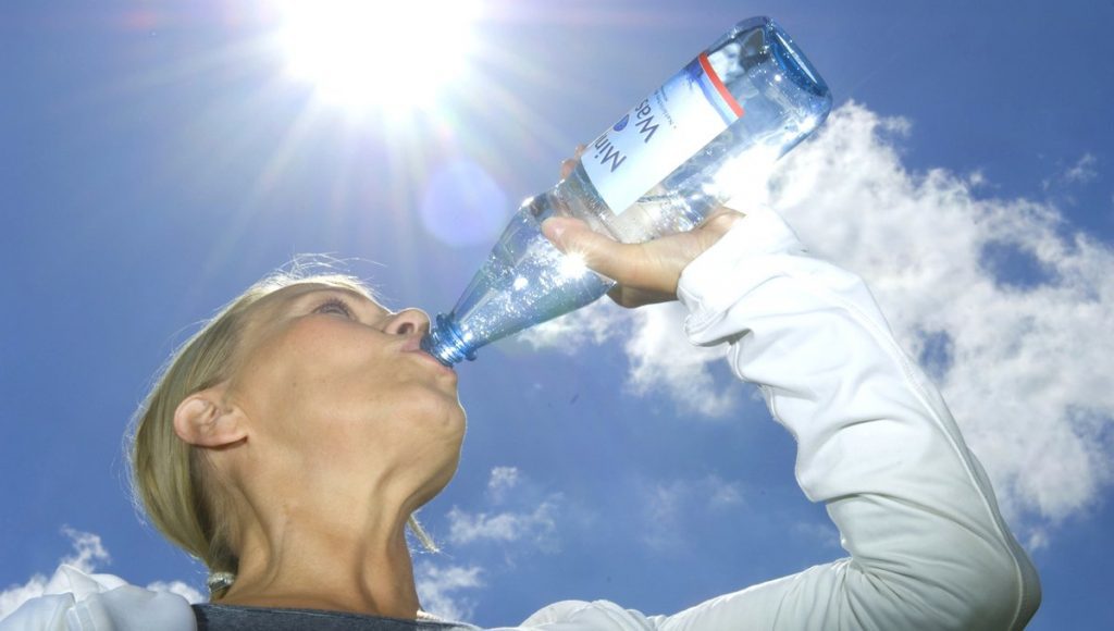 Frau trinkt aus Mineralwasserflasche