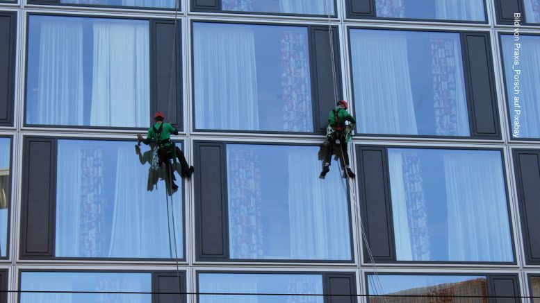 Zwei Fensterputzer reinigen ein Hotel von aussen