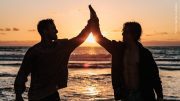 Zwei Männer vor einem Sonnenuntergang am Meer