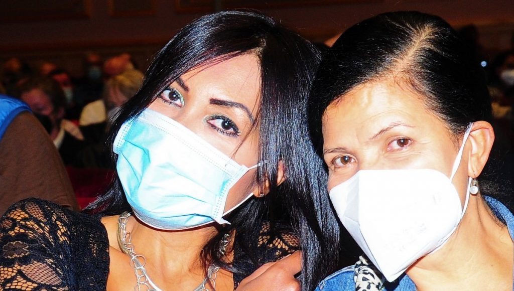 Zwei Frauen mit Mundmaske bei Rockkonzert