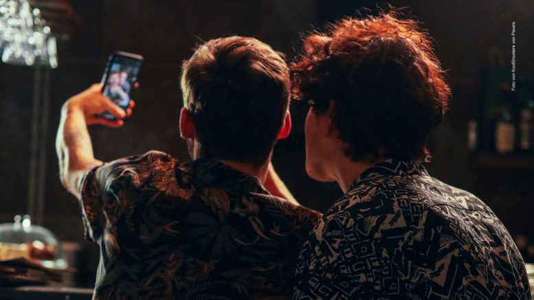 Ein schwules Paar in einer Bar macht ein Selfie