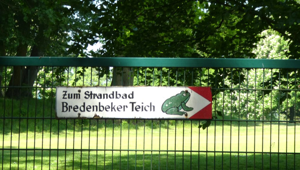 Hinweisschild an einem Zaun mit Frosch: Zum Strandbad Bredenbeker Teich