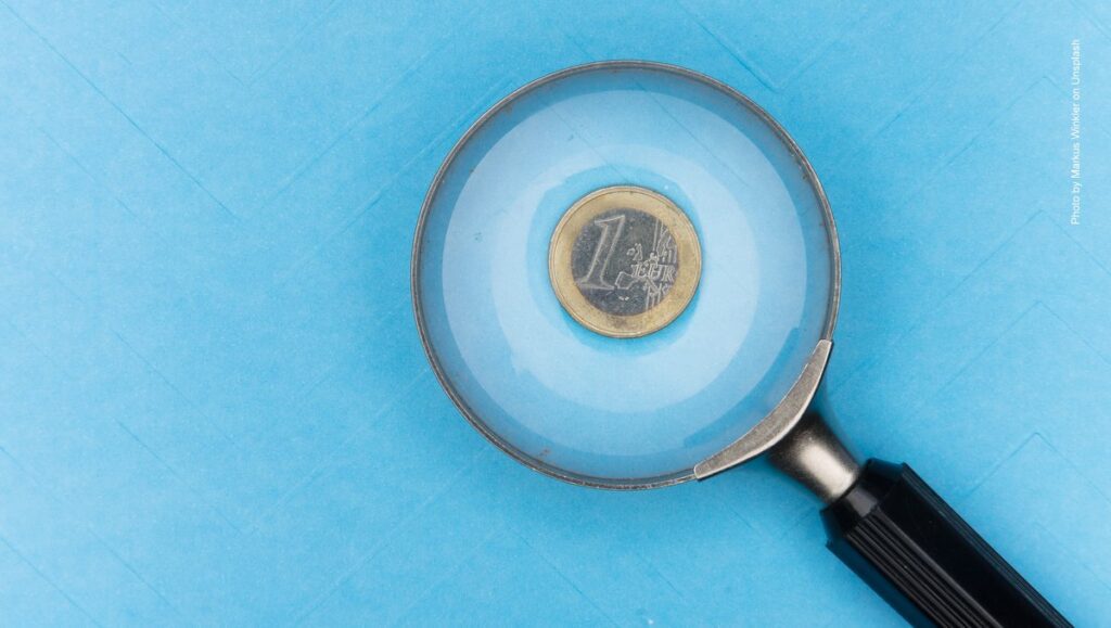 Eine Euromünze unter einer Lupe