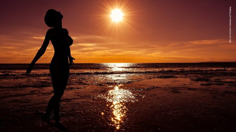 Sonnenuntergang am Strand, Frau als schwarze Silouette, goldfarbene Farbstimmung