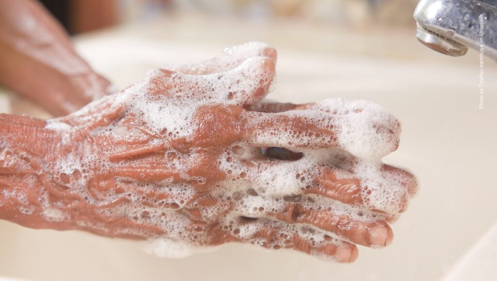 Händewaschen über dem Waschbecken mit Seife
