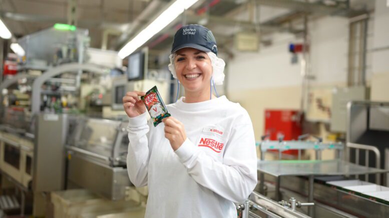Die Produktionsleiter Maren Grisar, zeigt im Wandsbeker Nesé Werk eine Packung KitKat Vegan und steht an einer Maschine