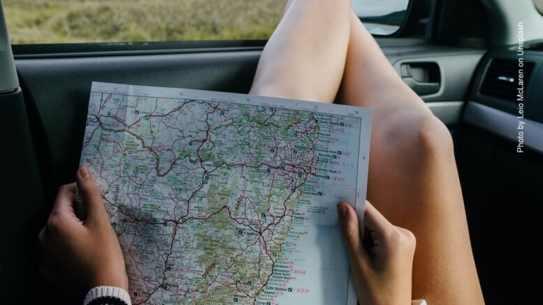 Frau schaut in eine Landkarte im Auto. Ganz lässige Haltung
